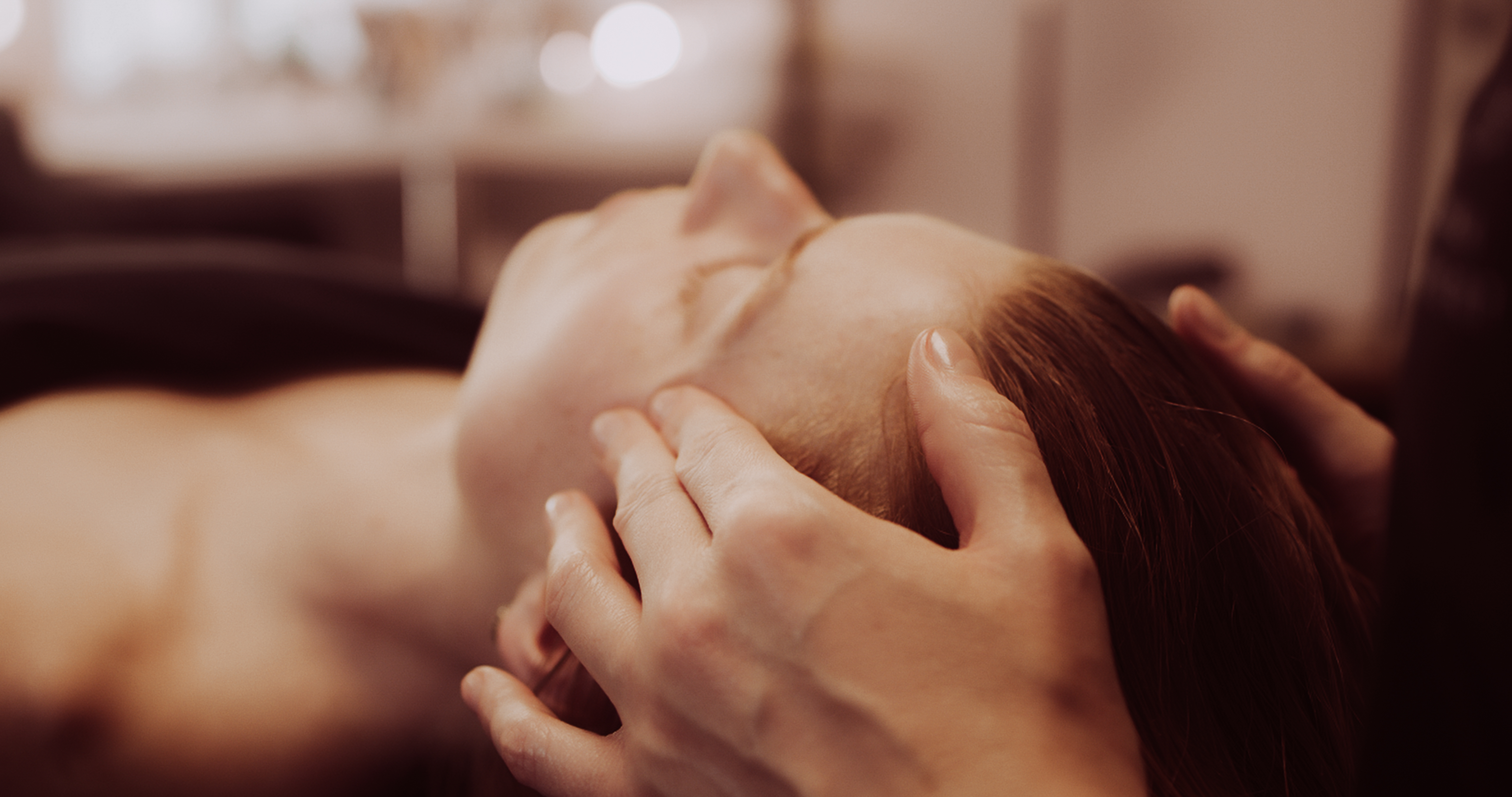 Kobido facial massage. The beautician is massaging the client's head.